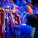 People are attaching colorful ribbons to the wooden structure of the galley.