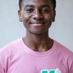 Smiling young person wearing a pink T-shirt with the text 